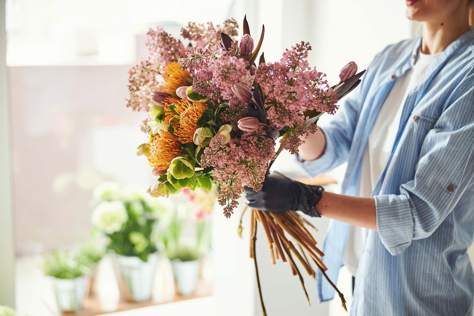 Floristin arrangiert einen fr&uuml;hlingshaften Strau&szlig; aus saisonalen Blumen
