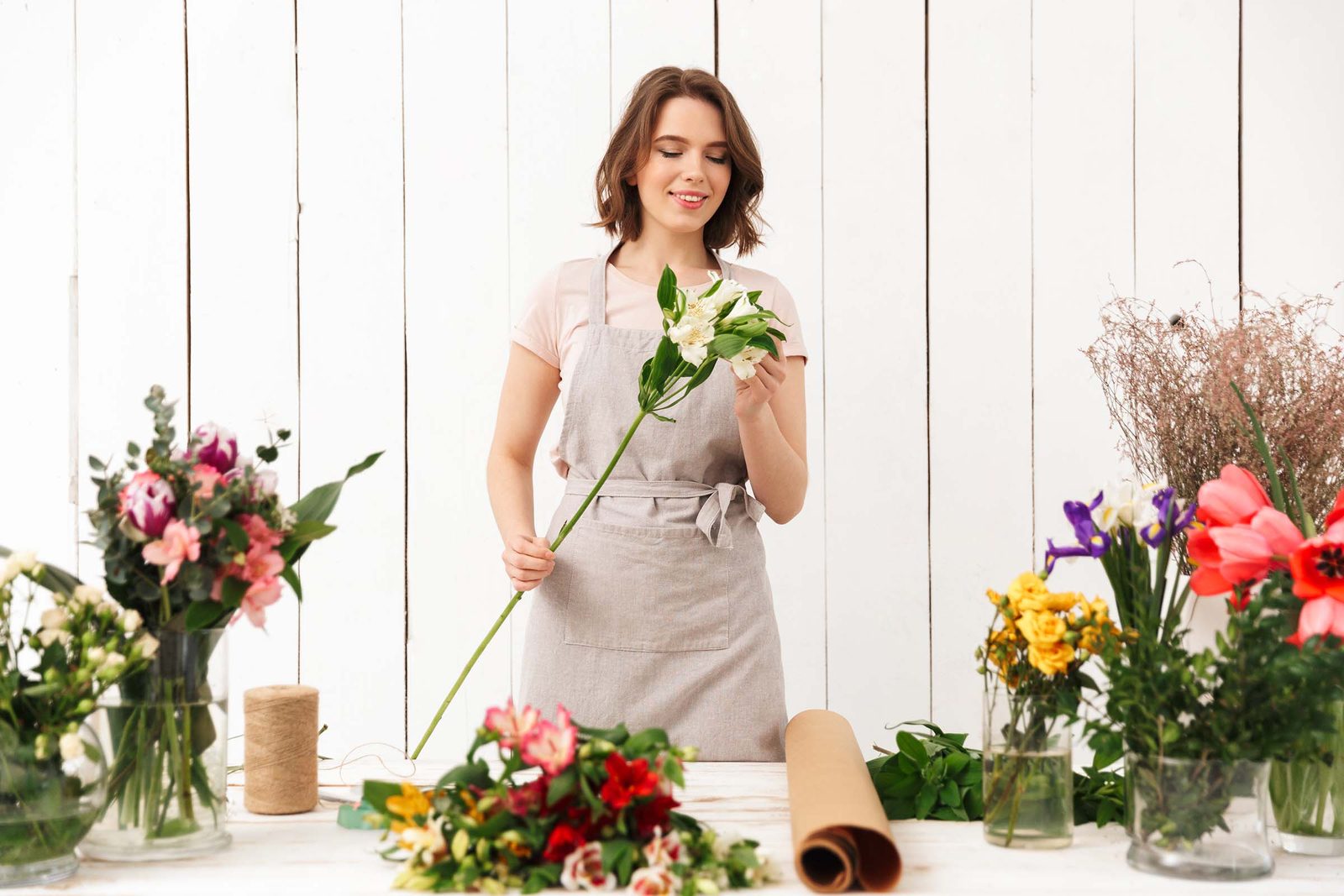 Werktisch voller Vasen mit frischen, gemischten Blumen