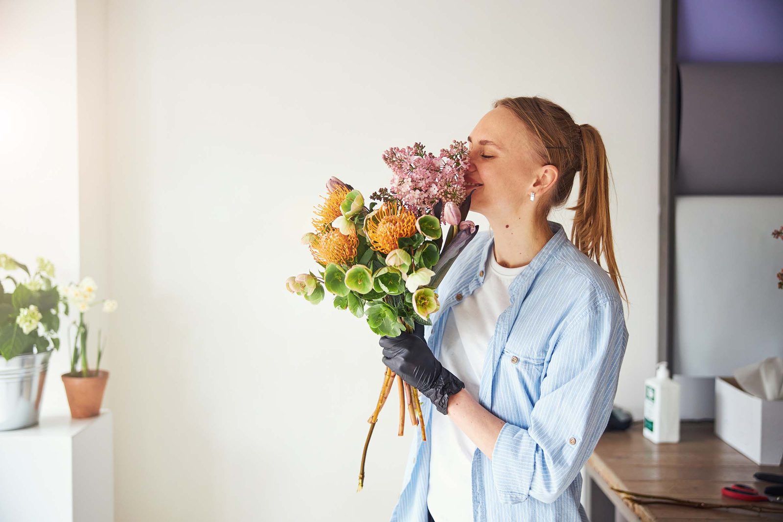 Floristin nimmt achtsam den Duft frischer Blumen in den H&auml;nden auf