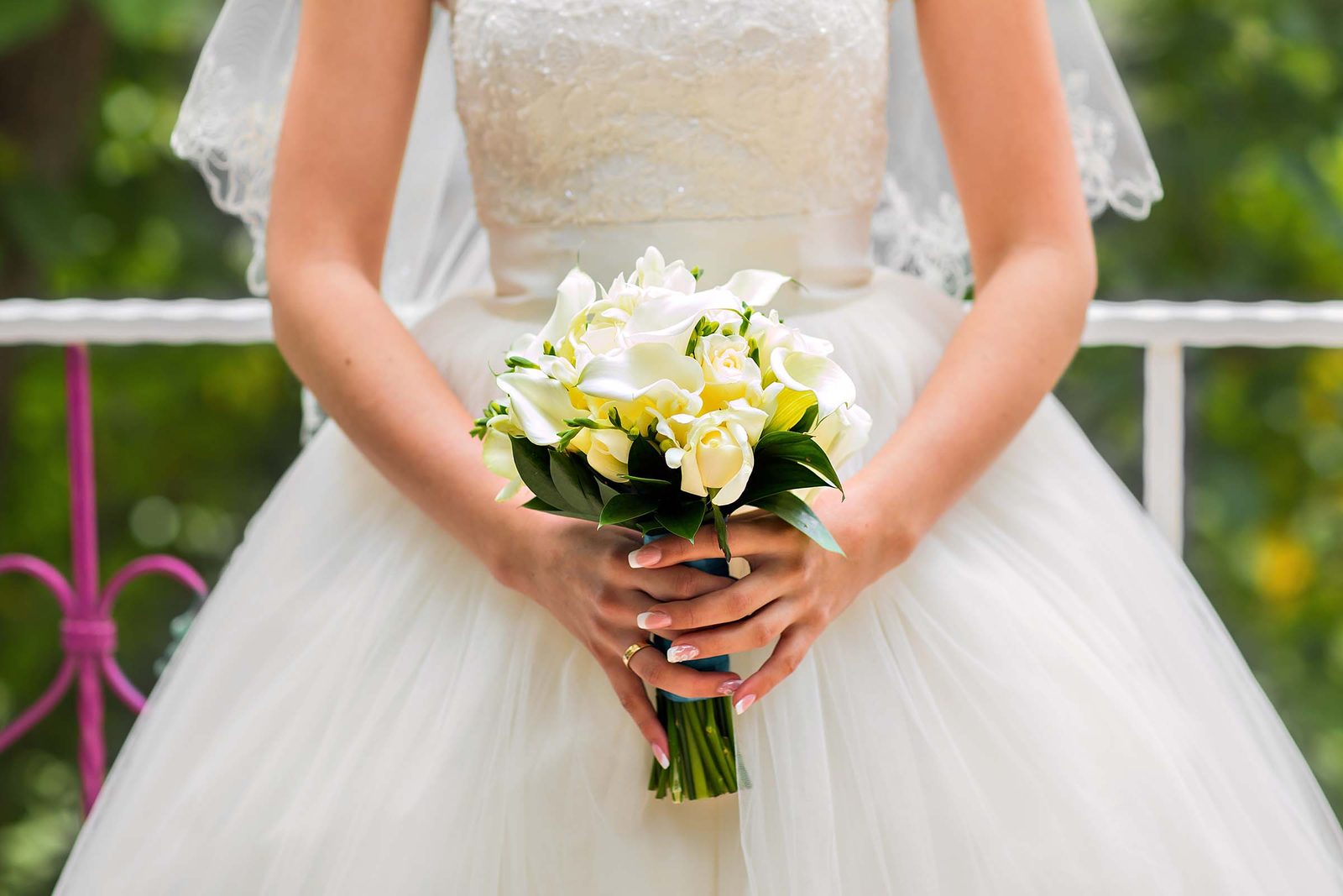 Braut h&auml;lt einen Brautstrau&szlig; aus wei&szlig;en Callas und Rosen